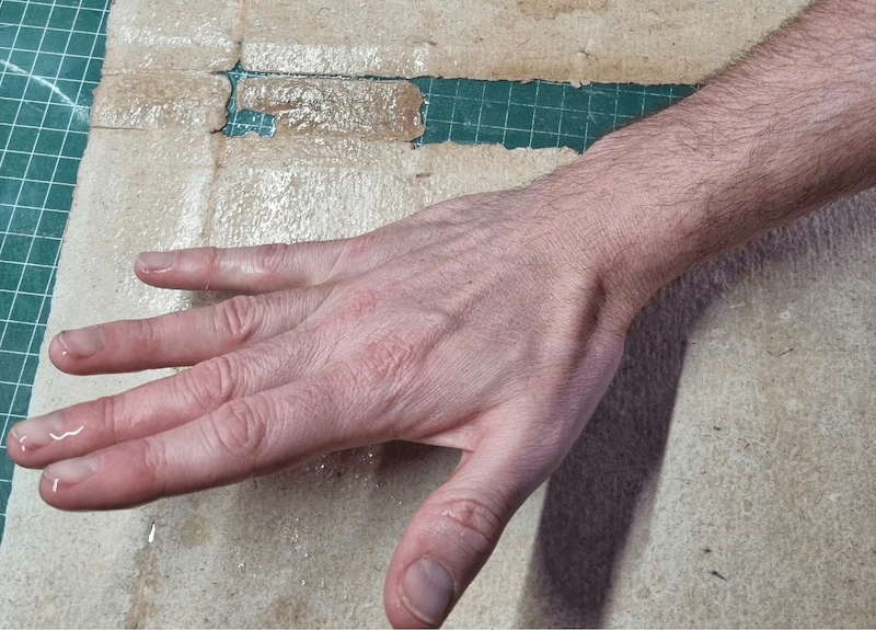 main massant une couverture de livre ancien à la tylose