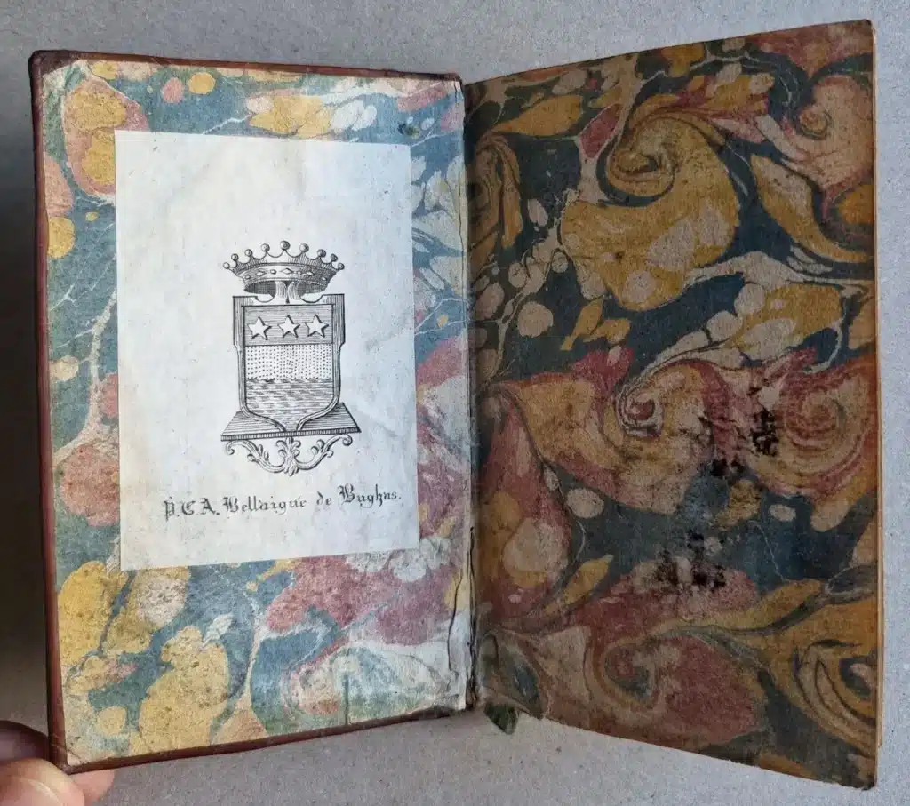 Ex-libris gravé armorié de P.C.A. Bellaigue de Bughas collé sur un contreplat de papier marbré
